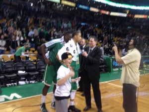 Justin next to Celtics player Courtney Lee on the basketball court post-game.