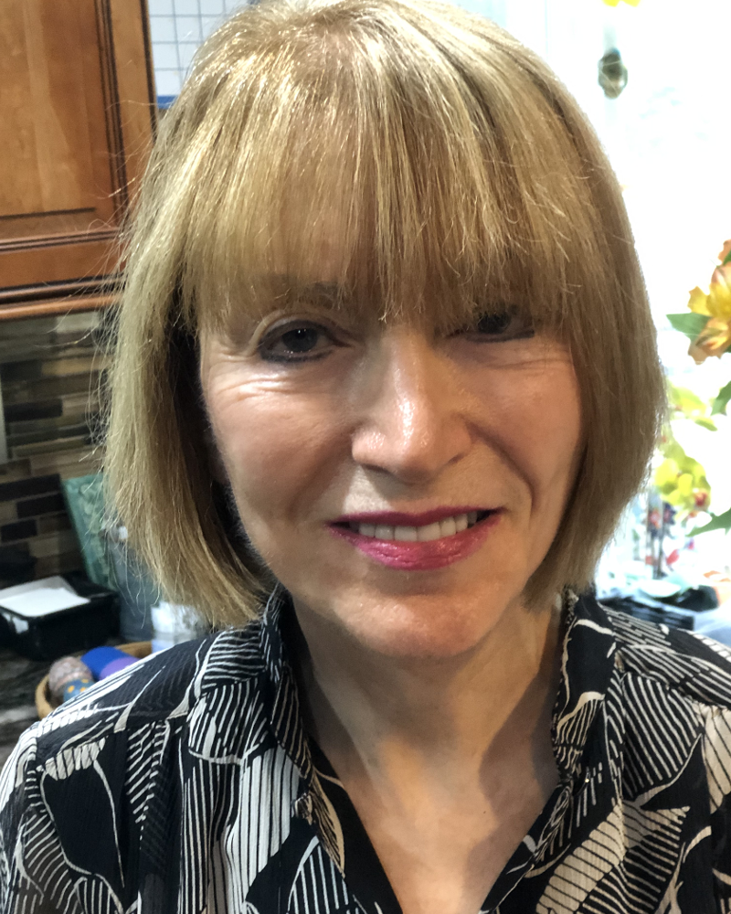 A White woman with blond hair who is smiling in this photo