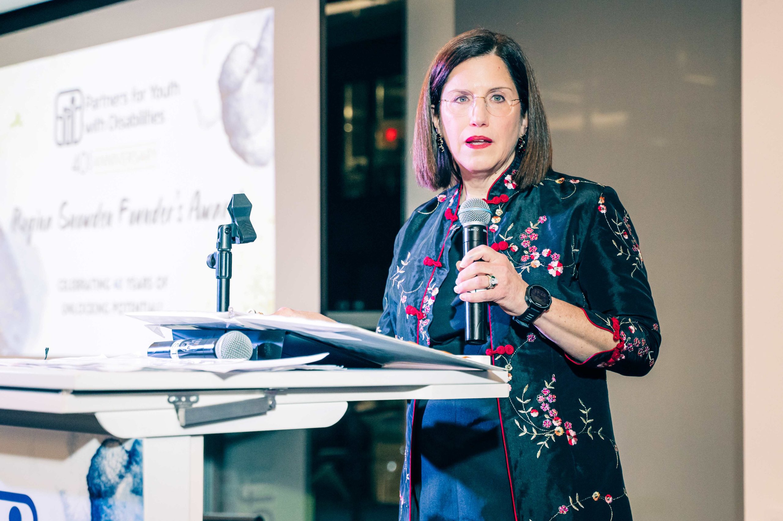 Executive Director, Tere Ramos speaks into a microphone