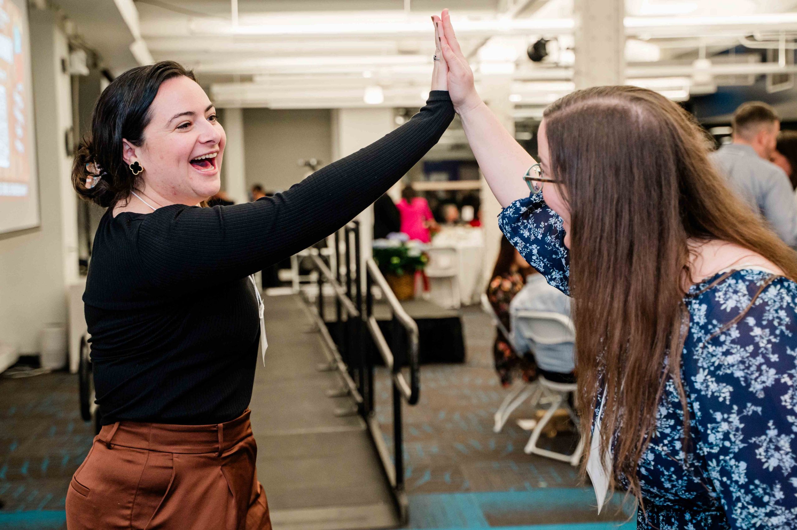 Staff members Rachel and Becca high-five.