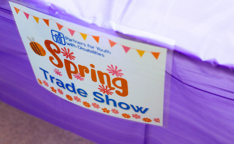 A sign that says PYD Spring Trade Show is taped to a table.