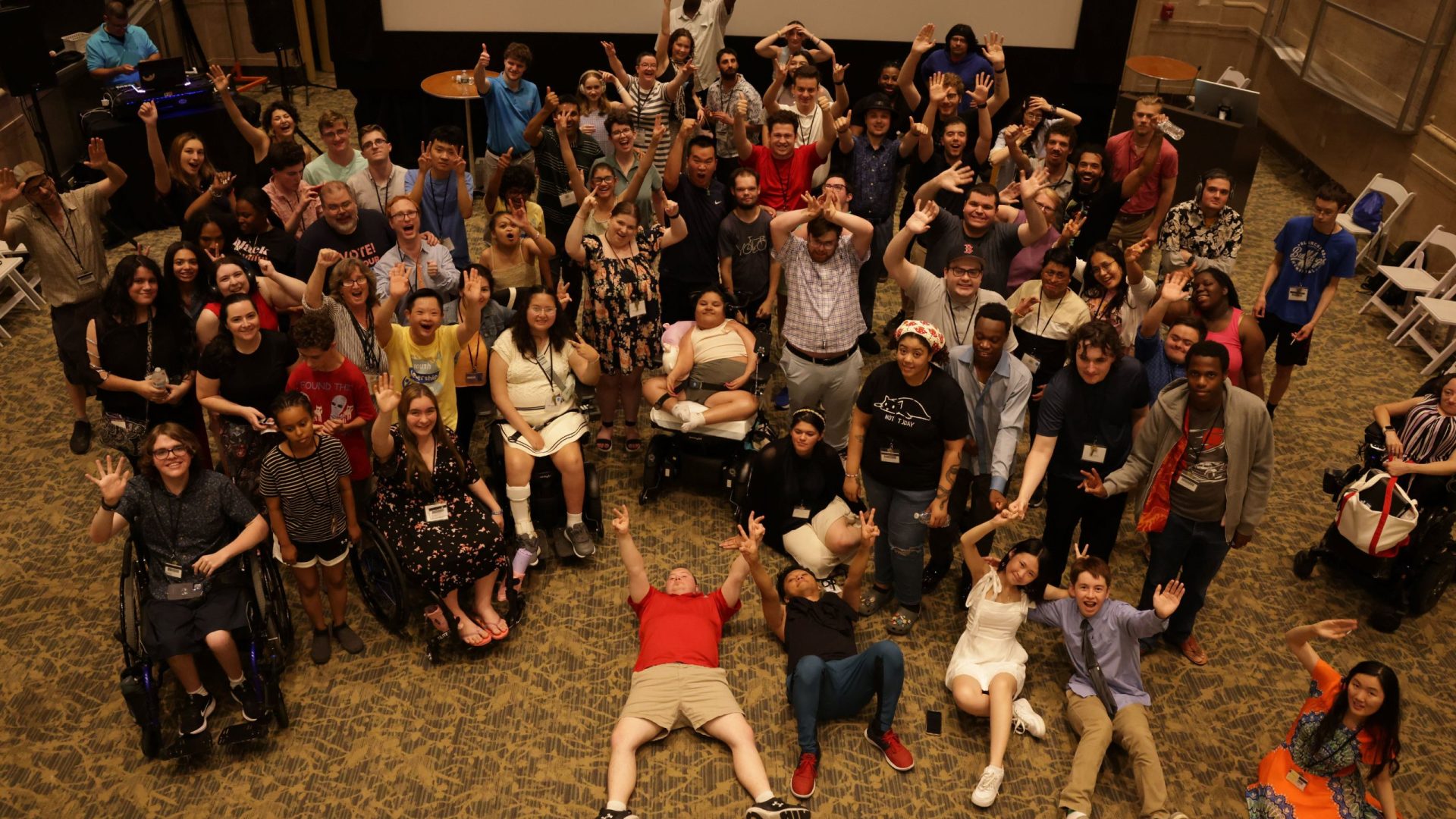 YLF participants pose for the camera, all in different poses, including lying on the ground, putting peace signs, or arms up.