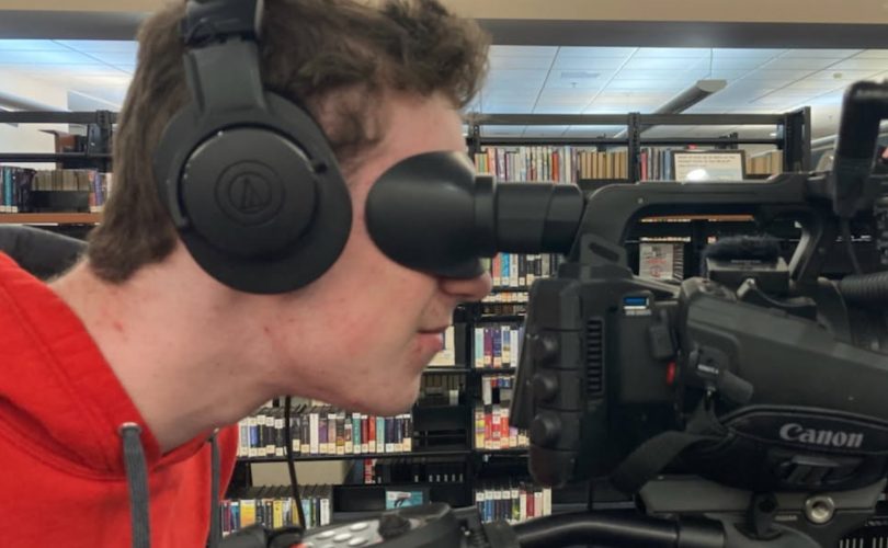 Kyle looks through a camera at his BATV internship.