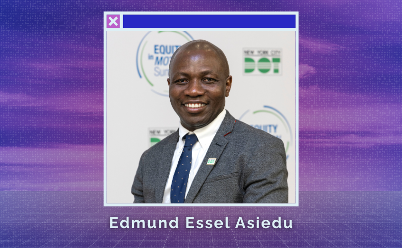 With a smile and seated in a wheelchair, Edmund Asiedu is wearing gray suit jacket, white shirt and a dark blue tie.