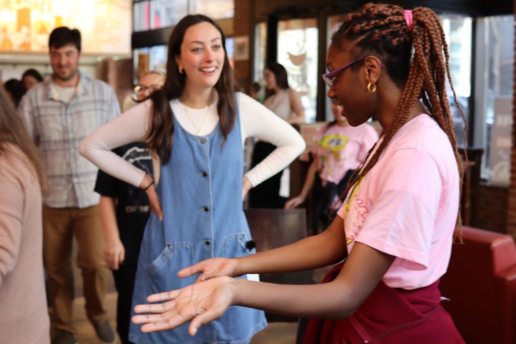 PYD student gestures toward a customer.