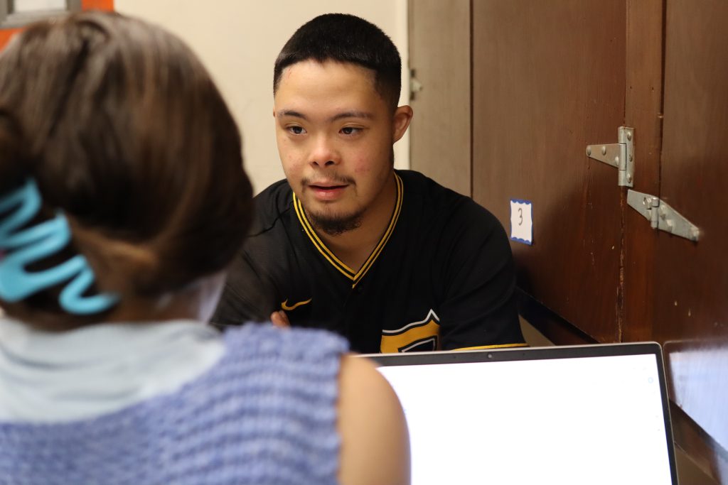A student sits across from a staff member, answering practice questions.