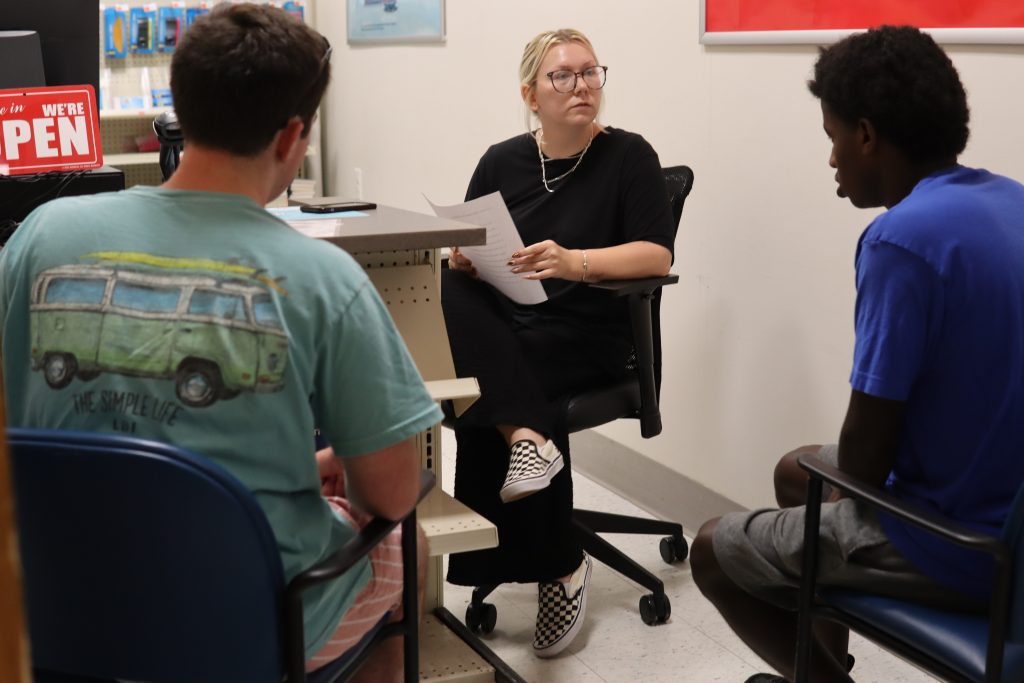 Two students sit across from a PYD staff member in a mock interview.